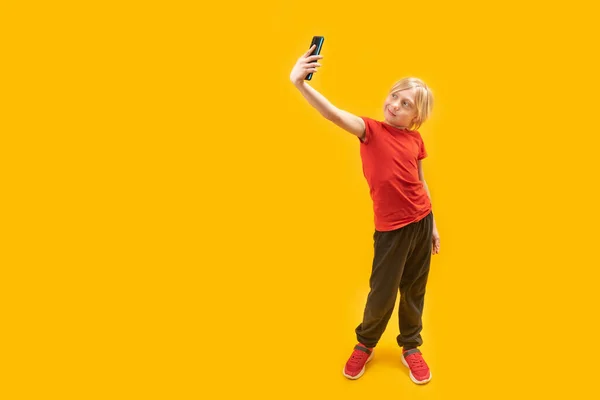 Ett Långt Porträtt Vithårig Pojke Röd Shirt Med Telefon Händerna — Stockfoto