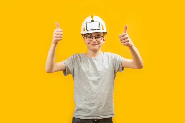 高中学生戴着防护头盔 用双手在黄色背景上竖起大拇指 职业选择 — 图库照片