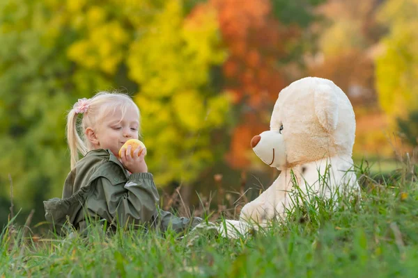Χαριτωμένο Κοριτσάκι Μήλο Παίζει Μεγάλη Μαλακή Αρκούδα Κάθεται Στο Γρασίδι — Φωτογραφία Αρχείου