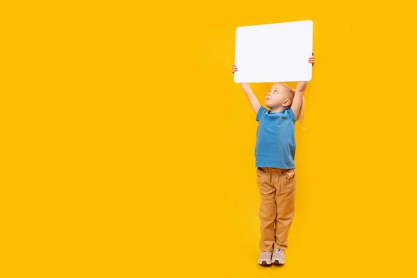 stock image Little girl blank blanc white sheet of paper high above her head. Child with an empty white board. Copy space