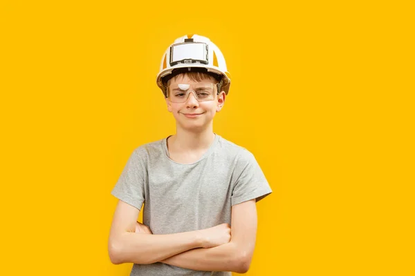 白人少年男孩戴着眼镜和头盔 双臂交叉在胸前 用黄色背景看着摄像机 复制空间 — 图库照片