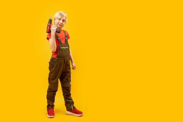 Блондинка Хлопчик Підліток Робочому Комбінезоні Тримає Дриль Руках Навчання Робочими — стокове фото