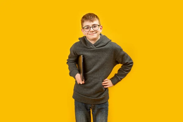 Tiener Schooljongen Casual Kleding Bril Houdt Laptop Glimlachen Gele Achtergrond — Stockfoto
