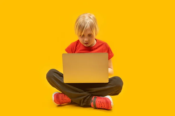 10代の男の子はノートパソコンを手に床に座り モニターを注意深く見ています 近代教育 子供向けプログラミング — ストック写真