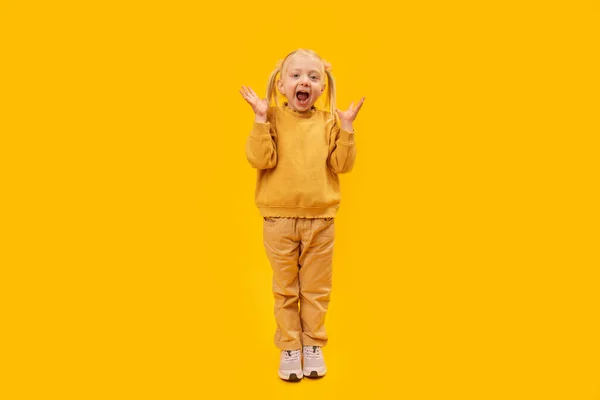 小女孩是尖叫或惊讶 黄底黄衣学龄前女童全长肖像 — 图库照片