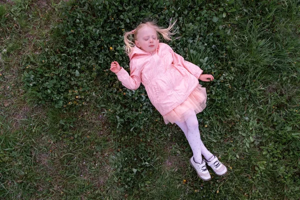 Gyermek Lány Fekszik Füvön Óvodás Lány Rózsaszín Kabátban Lefeküdt Pihenni — Stock Fotó