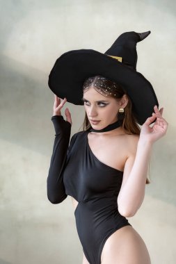 Siyah elbiseli ve cadı şapkalı genç seksi kadın. Cadılar Bayramı partisi, seksi şey. Beyaz arkaplan