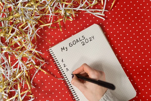 Manos Femeninas Escribiendo Mis Metas 2024 Cuaderno Fondo Rojo Oropel Fotos De Stock Sin Royalties Gratis