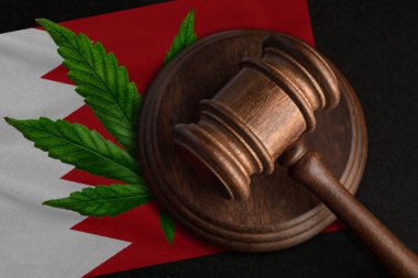 Bahreyn bayrağı ve kenevir yapraklı adalet tokmağı. Esrar bitkisinin ve uyuşturucuların yayılmasının yasadışı büyümesi