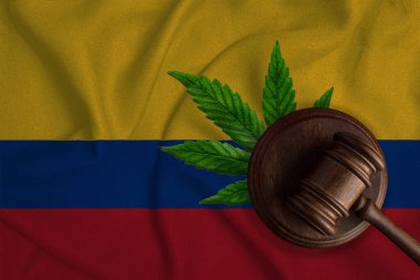 Kolombiya bayrağı ve kenevir yapraklı adalet tokmağı. Esrar bitkisinin ve uyuşturucuların yayılmasının yasadışı büyümesi.