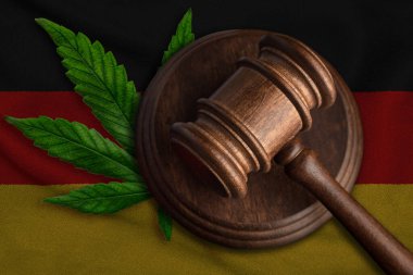 Almanya bayrağı ve kenevir yapraklı ahşap tokmak. Esrar bitkisinin ve uyuşturucuların yayılmasının yasadışı büyümesi