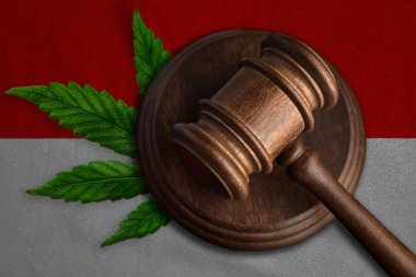 Endonezya bayrağında kenevir yaprağı olan tahta tokmak. Esrar bitkisinin ve uyuşturucuların yayılmasının yasadışı büyümesi.