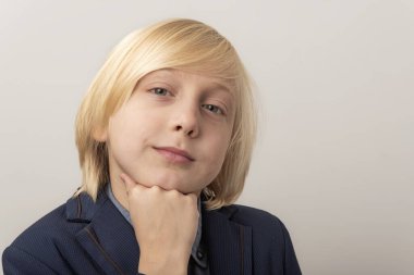 Sarı saçlı ve mavi takım elbiseli bir gencin portresi. Kapat..