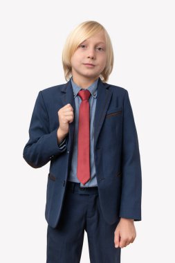 Mavi takım elbiseli ve kırmızı kravatlı küçük bir çocuk. Beyaz arkaplanda izole