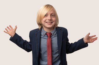 Mavi gömlekli, kırmızı kravatlı, mutlu bir çocuk portresi, el ve gülücükler saçıyor, beyaz arka planda izole edilmiş..