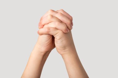 Gri arka planda yalıtılmış, birbirine sarılan kadın ellerine yakın..