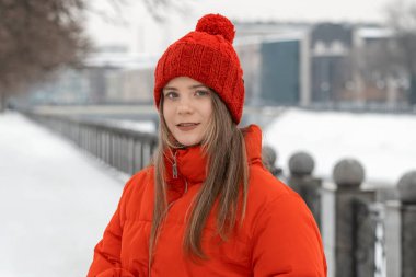 Kırmızı ceketli ve örgü şapkalı güzel bir kızın portresi..