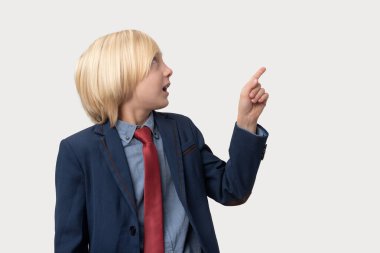 Mavi ceketli ve kırmızı kravatlı genç sarışın işadamı beyaz arka planda izole edilmiş bir şeyi işaret ediyor.