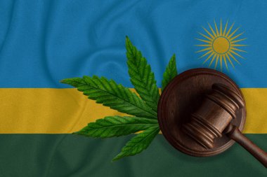 Gavel ve Ruanda bayrağı üzerinde kenevir yaprağı resmi var. Ülkede marihuananın yasallaştırılması kavramı.