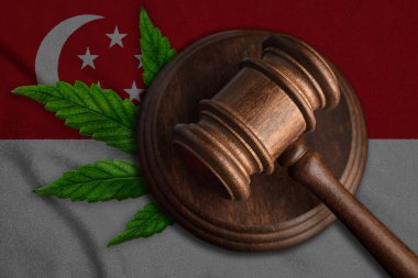 Singapur bayrağında hakimler tokmak ve marihuana yaprağı. Esrarın yasallaştırılması kavramı.