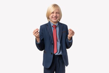 Takım elbiseli gülümseyen bir çocuğun portresi bana para kazandıran bir jest gösteriyor. Beyaz arkaplanda izole.