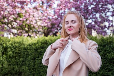 Çekici bir genç kadın. Avrupa 'nın dış görünüşü konusunda gözleri kapalı. Spring Park 'ta ceketli modern bir kadın. Başarılı bir iş kadını.