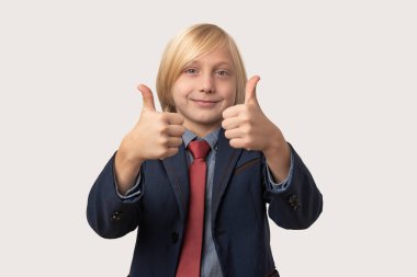 Sarı saçlı, kırmızı kravatlı, beyaz arka planda geniş bir şekilde gülümseyen beyaz çocuk.