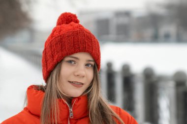 Karlı bir günde kırmızı şapkalı bir kızın portresi..