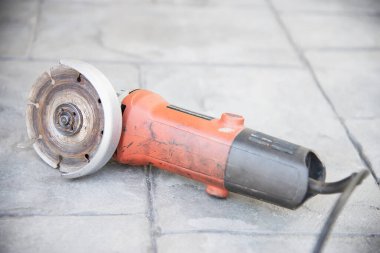 used electrical angle grinder on gray cement floor, famous construction hand tool machine