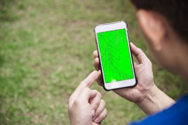 Man seriously looking at mobile phone with broken cracked screen display need to be fixed, mobile repair shop concept