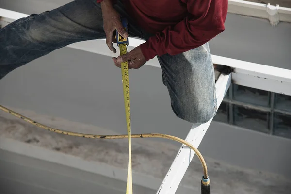 stock image onsite construction worker with steel roof structure installation, residential building contractor job