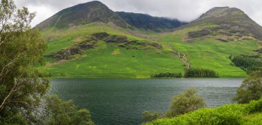 Kırmızı Turna ve Yüksek Stil 'in at gösterisi yağmurlu bir yaz gününde Buttermere' in üzerinde yükseliyor.