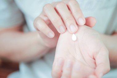 Nemlendirici el kremi kullanmak üzere olan bir kadın. Elin sağlık hizmeti kavramı.