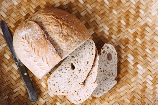 The sourdough bread with a knife cut into slices is a natural yeast fermented bread.