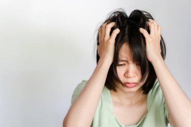 Beyaz arka planda mantar olduğu için kafasını kaşıyan Asyalı kadın..