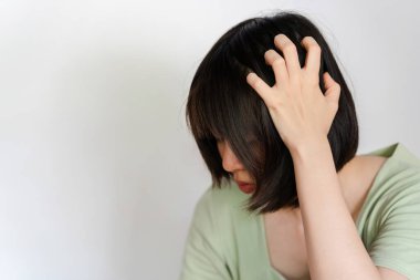 Asyalı kadın kepek yüzünden kaşınıyor ya da beyaz arka planda kafa derisi mantarı..