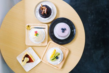 Ahşap bir masanın üzerinde şirin bir tarzda çeşitli lezzetli kekler..