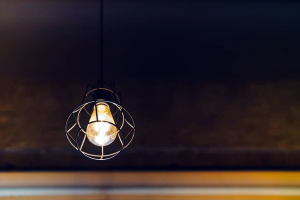 Light bulbs hanging from the vintage ceiling glow a golden yellow. Copy space.