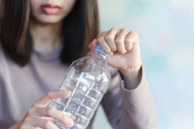 Şişeyi tutan ve su içmek için su şişesinin kapağını açan kadınlar..