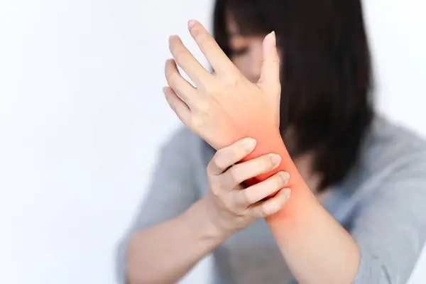 A woman's wrist is in pain and a red area is made to show the pain point.