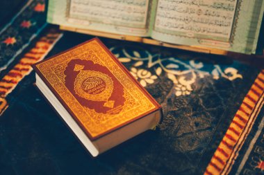 Kuran, İslam 'ın kutsal kitabı, burada bir dua paspasında yatarken resmedilmiştir. Kitap, Arapça yazılmış bir sayfayı açıyor..