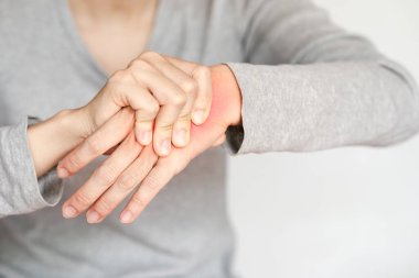 Bileği ağrıyan, hayal kırıklığına uğramış ifadesini ve günlük aktivitelerde rahatsızlığını gösteren birinin yakın plan görüntüsü..
