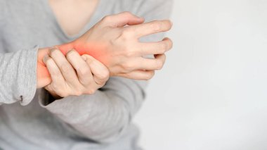 Bileği ağrıyan, rahatsızlığı ve sağlık bilinci ihtiyacını gösteren bir kişinin yakın çekimi..