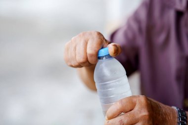 Serinletici su şişesi ellerle açılıyor, sergileniyor..