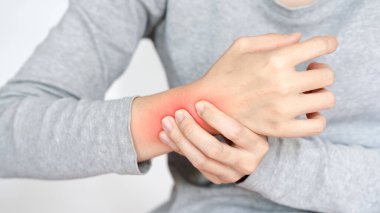 Rahatsızlık hisseden kişi bileğini tutarken görülüyor. Ağrı ya da tahrişe işaret ediyor. Görüntü endişe anını yakalar ve sağlık bilincinin önemini vurgular.