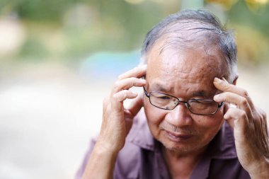 Bunalmış hisseden, gözlüklü yaşlı adam başını dertli tutuyor, derin düşünce ya da endişe anlarını yansıtıyor. İfadesi endişe ve tefekkür hissi veriyor..