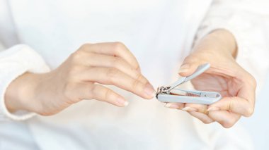 Tırnak makasıyla tırnak bakımını, kişisel bakımını ve kişisel bakımını yapıyor..