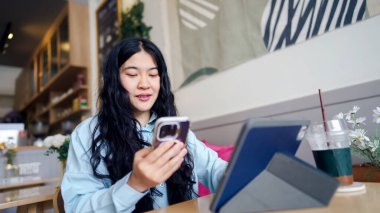 İş kadını danışman motivasyon konsepti. Samimi bir kafede akıllı telefon ve tablet kullanan biri..