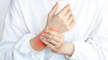 Bilek ağrısı kronik terapi konsepti. Nazik eller bir bileğin üzerinde dinleniyor, özen ve ilgi gösteriyorlar..