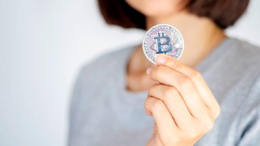 Dijital para ve modern finansı sembolize eden bir Bitcoin tutan kişi.